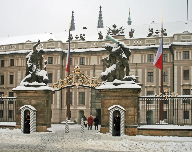 Poarta Castelului din Praga, cu statuile de pe stâlpi, iarna, sub zăpadă